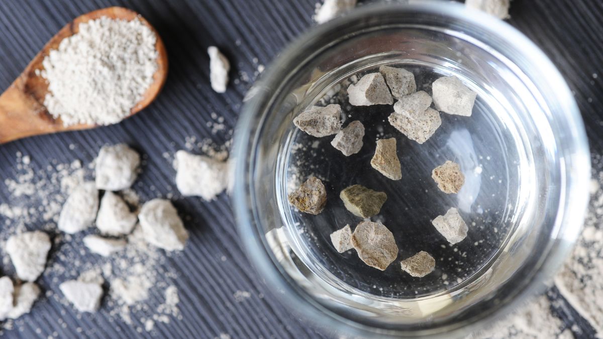 Glas mit Wirkstoff-Pulver MANC (Zeolith) – Sinnbild für effektive Entgiftung